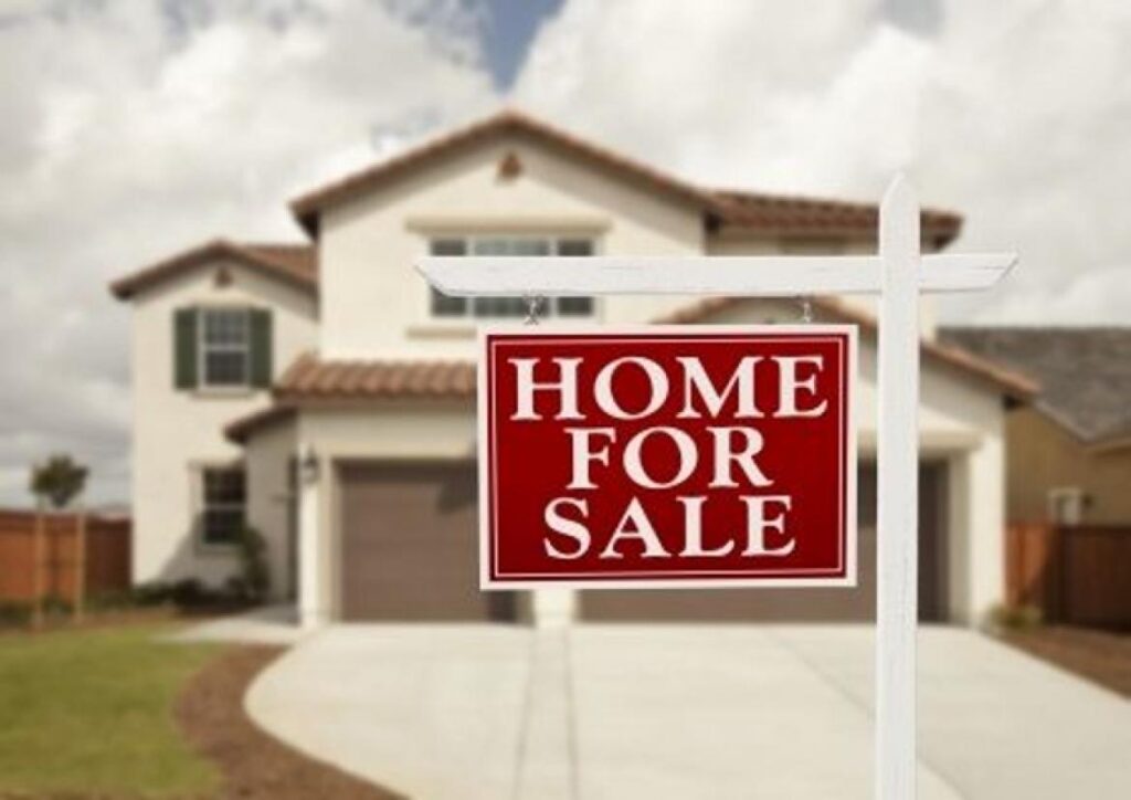 house with For Sale sign in yard