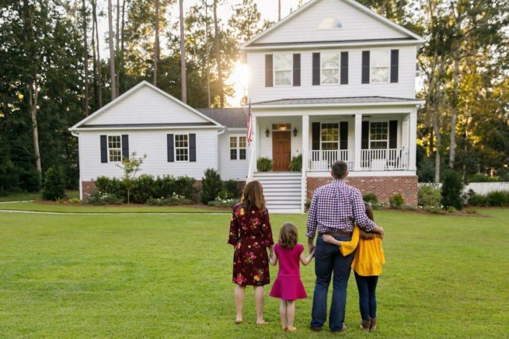 family standing in front of new house