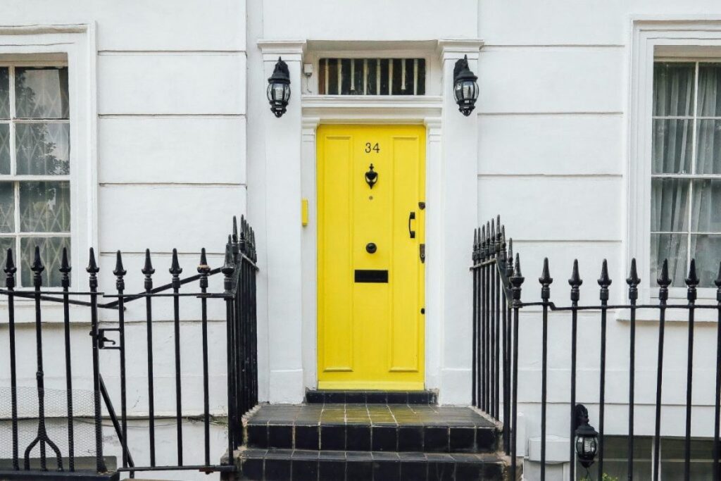 close up of yellow door on white house