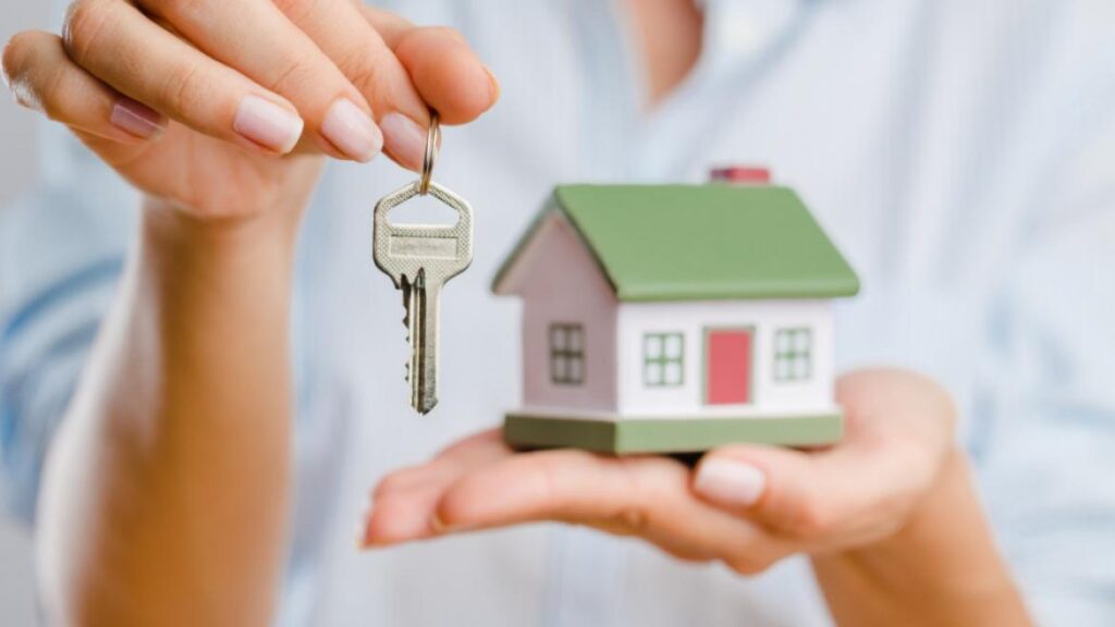 female realtor holding model of house and keys