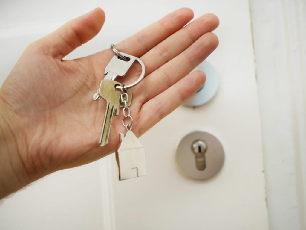 hand holding a key at a door