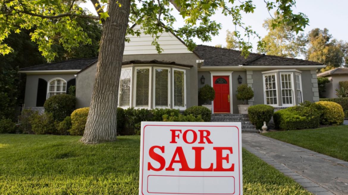 gray house with for sale sign in yard