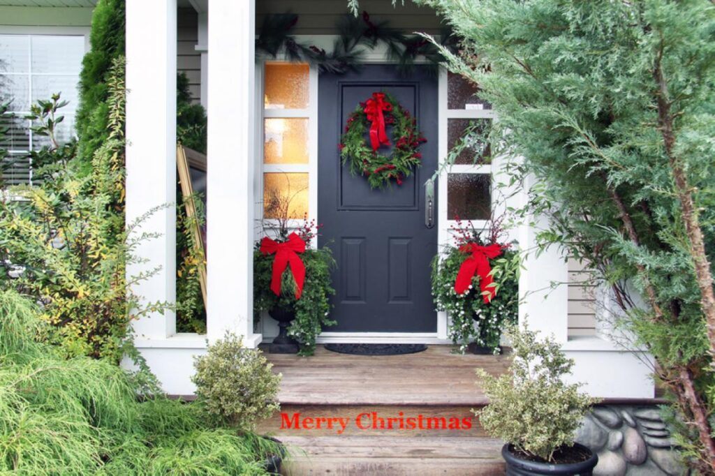 white house with black door with wreath hung on it